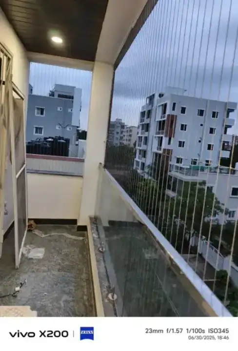 Invisible grill installation for modern apartment balcony with city view in T. Nagar Chennai